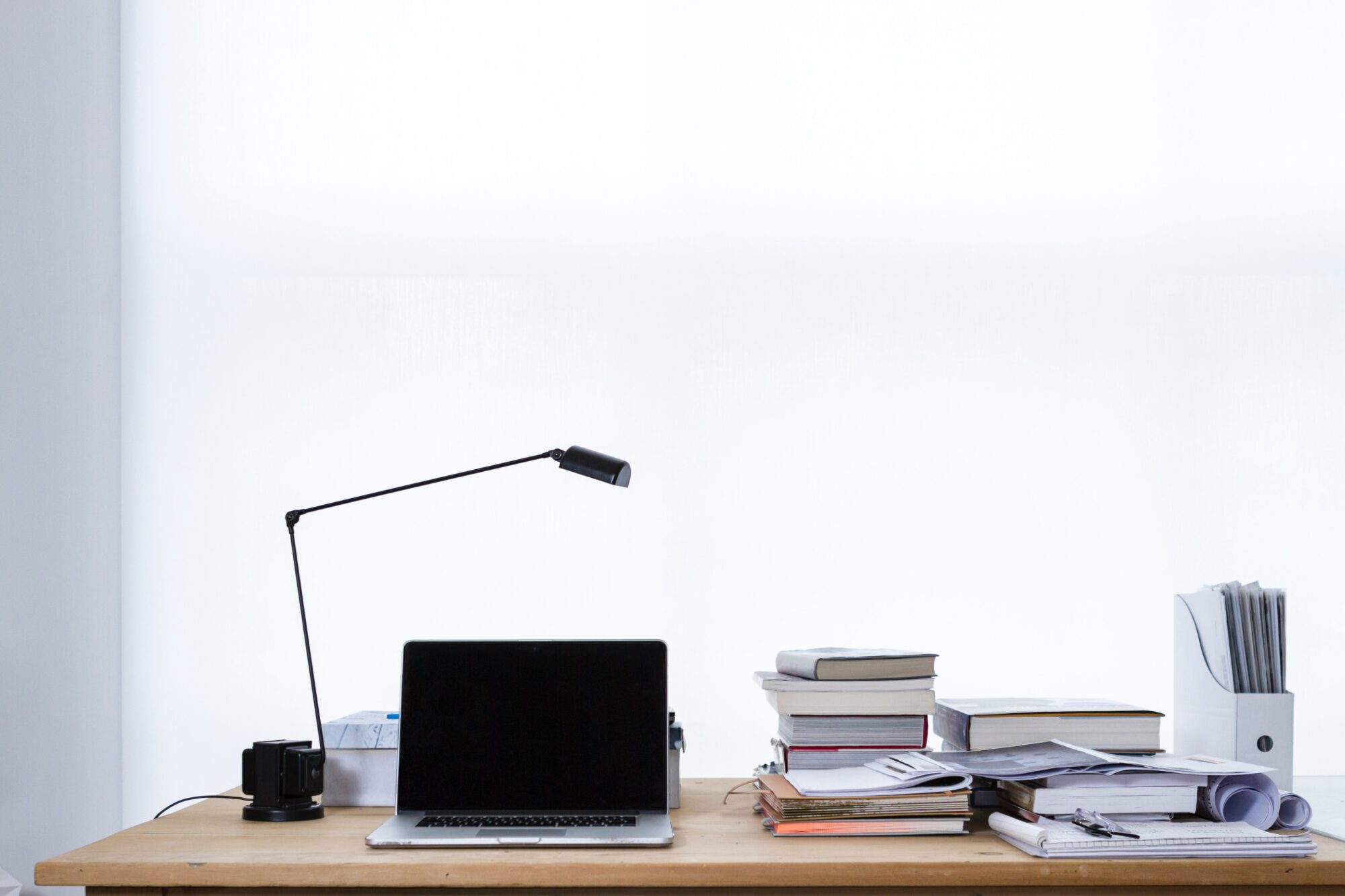 Desk with lamp, books and laptop